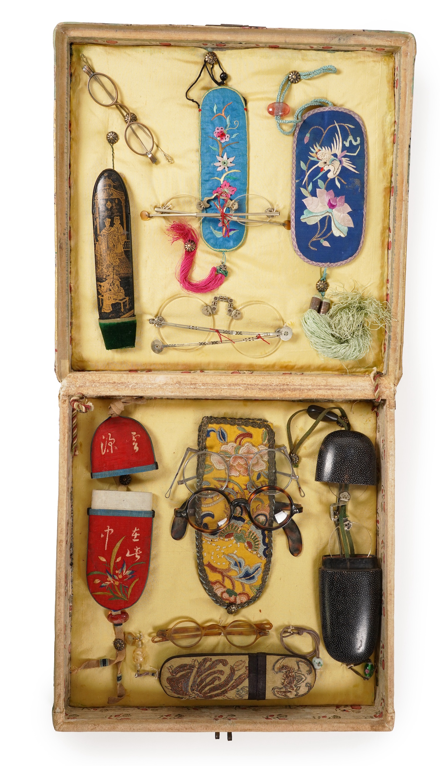 A collection of 19th/20th century Chinese embroidered silk spectacle cases and various spectacles, Box 33cm square